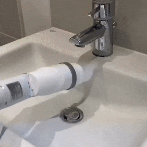 Mopa eléctrica limpiando el borde de un lavabo con espuma